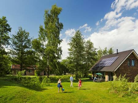 Kinderen spelen in de tuin van een vakantiehuis op vakantiepark Landal Aelderholt