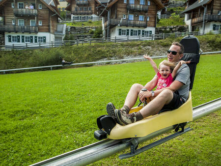 Vader en dochter rodelen op de Rodelbaan van Landal Alpen Chalets Katschberg