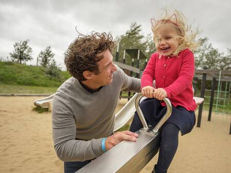 Meisje op een wipwap in een speeltuin op vakantiepark Landal Beach Park Ebeltoft