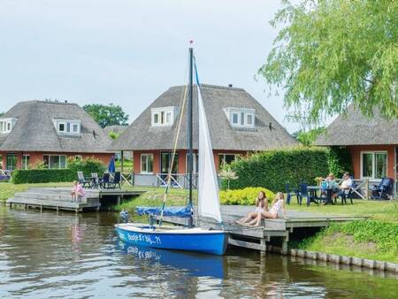 Een bootje ligt aan de steiger van een vakantiehuis op vakantiepark Landal De Bloemert