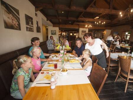 Gezin aan tafel bij restaurant Auberge De Hilver op vakantiepark Landal Duc de Brabant