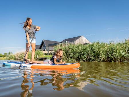 Moeder en dochter suppen op een kanaal op vakantiepark Landal Elfstedenhart