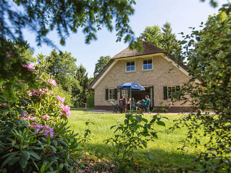 Gezin in een grote tuin van een vakantiehuis op Landal Het Land van Bartje