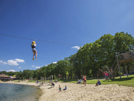 Jongen op de tokkelbaan over de recreatieplas op vakantiepark Landal Landgoed 't Loo