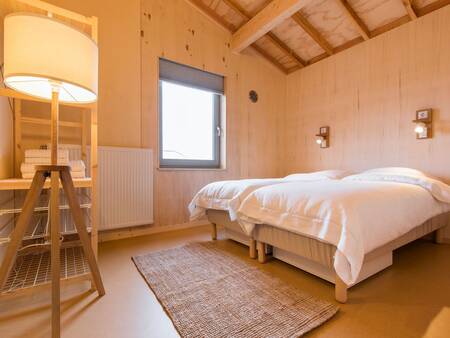 Slaapkamer met tweepersoonsbed van een vakantiehuis op vakantiepark Landal Marker Wadden