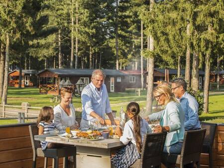 Gezin dineert op het terras van Grand Café Narvik op vakantiepark Landal Mooi Zutendaal