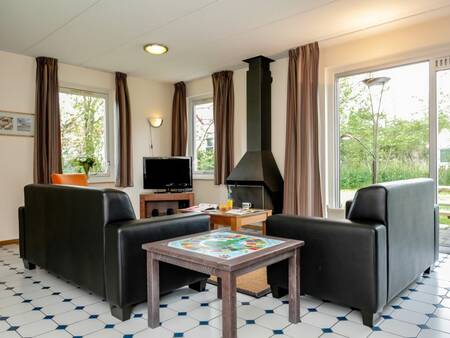 Woonkamer met open haard van een vakantiehuis op vakantiepark Landal Natuurdorp Suyderoogh