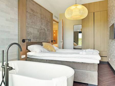 Slaapkamer met ligbad van een appartement op Landal Résidence Westduin