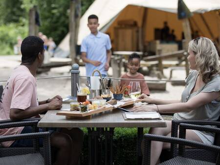 Genieten van een hapje en drankje op het terras van vakantiepark Landal Twenhaarsveld