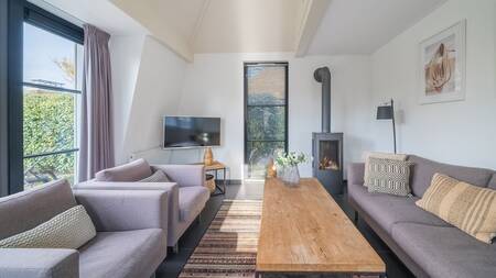 Woonkamer met houtkachel van een vakantiehuis op Landal Vakantiepark Duynvallei