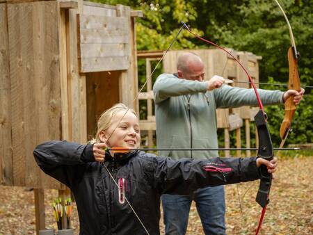 Vader en dochter zijn aan het boogschieten op Landal Vakantiepark Søhøjlandet