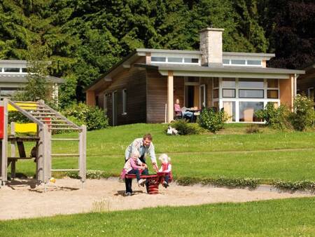 Vader met 2 kinderen in de speeltuin op vakantiepark Landal Village l'Eau d'Heure