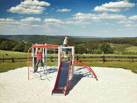 Kinderen klimmen in de speeltuin van vakantiepark Landal Village les Gottales