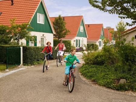 Gezin fietst tussen de vakantievilla's op vakantiepark Landal Villapark Livingstone