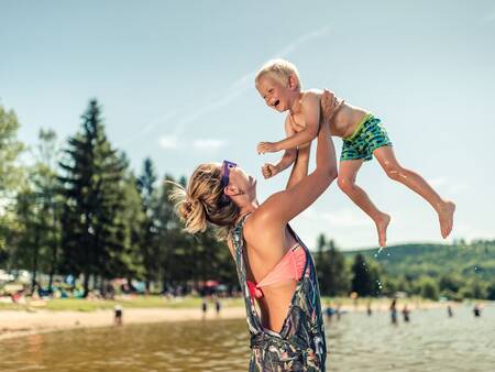 Vrouw met kind op het recreatiestrand van vakantiepark Landal Waterpark Marina Lipno