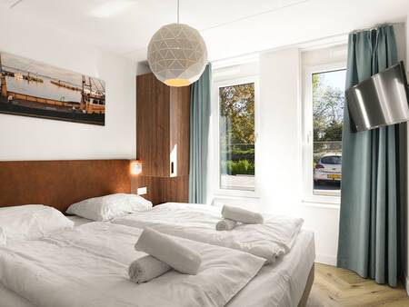 Slaapkamer met luxe tweepersoonsbed van een vakantiehuis op vakantiepark Landal Waterpark Volendam