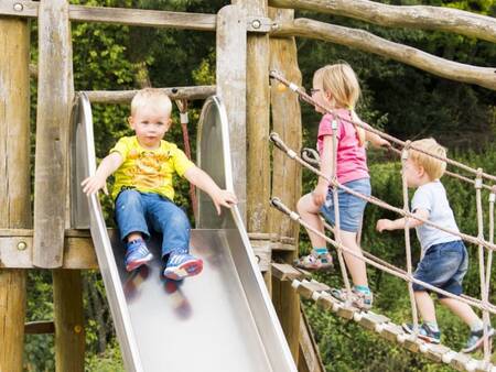 Kinderen op een speeltoestel in een speeltuin op vakantiepark Landal Wirfttal