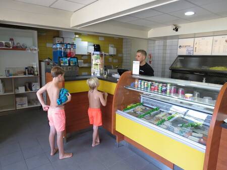 Twee kinderen kopen een ijsje in de snackbar van vakantiepark Landgoed De IJsvogel