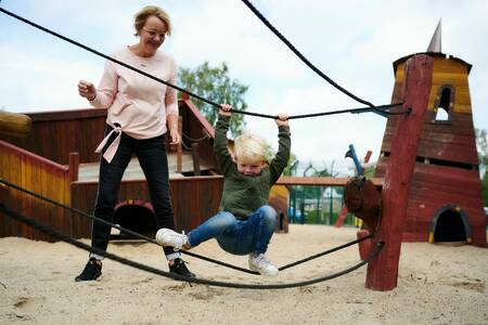 Kind aan het spelen in een speeltuin op vakantiepark Landgoed De IJsvogel