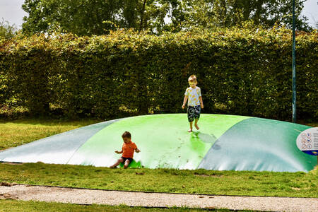 Kinderen spelen op de airtrampoline in de speeltuin van MarinaPark Residentie Bloemendaal