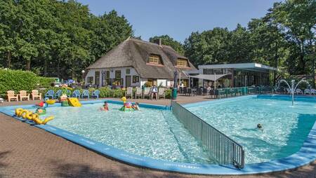 Mensen zwemmen in het buitenbad van vakantiepark Molecaten Park De Leemkule