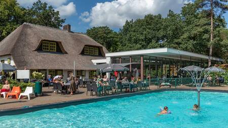 Het buitenbad ligt pal naast het restaurant op vakantiepark Molecaten Park De Leemkule