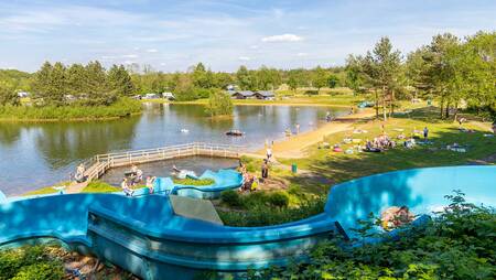 Mensen op de buiten glijbaan die uitkomt in het meer op vakantiepark Molecaten Park Kuierpad