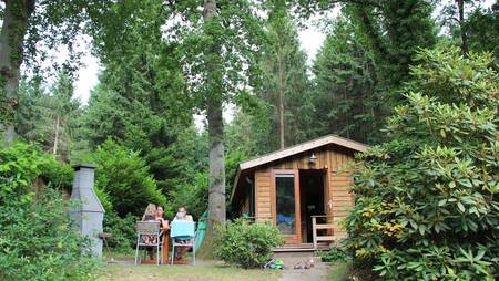 Gezin in de tuin van vakantiehuis type "'t Bos huus" op vakantiepark Park Landgoed Molecaten