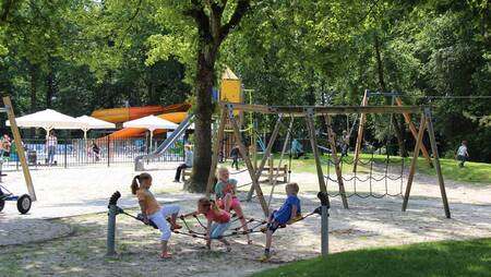 Kinderen spelen in een grote speeltuin op vakantiepark Molecaten Park ’t Hout