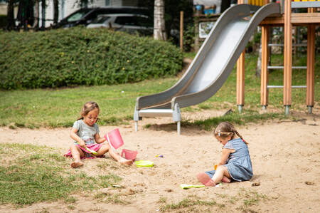 2 Meisjes spelen in het zand in een speeltuin op vakantiepark Petite Suisse