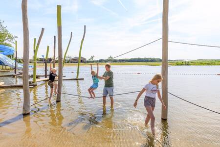 Kinderen spelen op speeltoestellen in het water op vakantiepark RCN de Flaasbloem