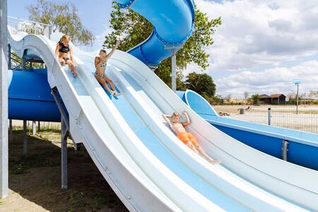 Kinderen op de waterglijbaan die uitkomt in het meer op vakantiepark RCN de Flaasbloem