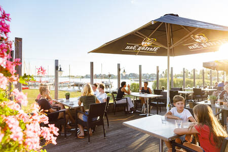 Mensen op het terras van de Brasserie op vakantiepark RCN de Potten