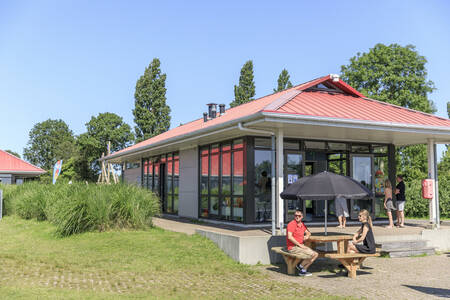 Mensen op het terras bij de snackbar op vakantiepark RCN de Potten