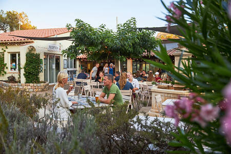 Mensen op het terras van het restaurant op vakantiepark RCN Domaine de la Noguière