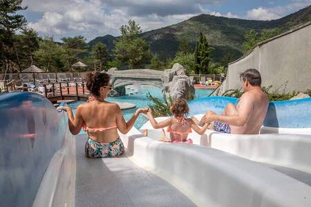 Gezin glijdt van een glijbaan in het buitenbad van vakantiepark RCN les Collines de Castellane