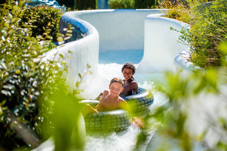 Kinderen op rubberbanden in de wildwaterbaan op vakantiepark RCN Val de Cantobre