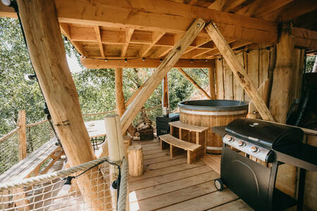 Een boomhut met een hottub en barbecue op vakantiepark Recreatiedomein Warredal