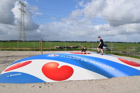 Kinderen springen op een airtrampoline in een speeltuin op Recreatiepark Tusken de Marren