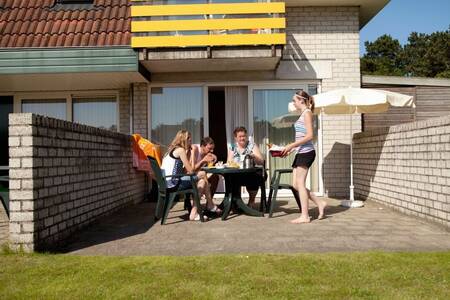 Mensen op het terras van een appartement op Roompot Appartementencomplex Bosch en Zee