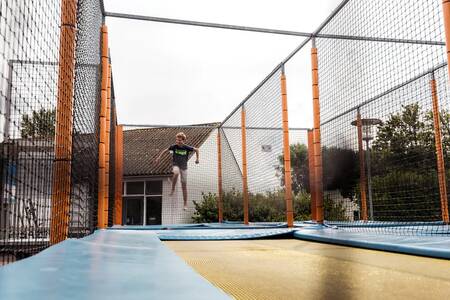 Een kind aan het springen op een trampoline op vakantiepark Roompot Beach Resort