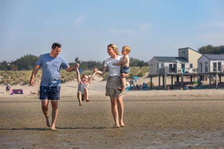 Gezin op het strand en Beach Houses van vakantiepark Roompot Beach Resort