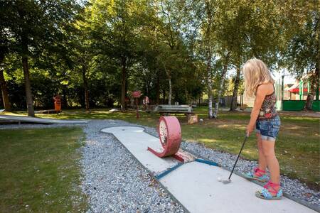 Meisje golft op de midgetgolfbaan van vakantiepark Roompot Bospark Lunsbergen