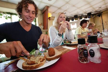 Mensen aan het lunchen bij een restaurant op vakantiepark Roompot Bospark Lunsbergen