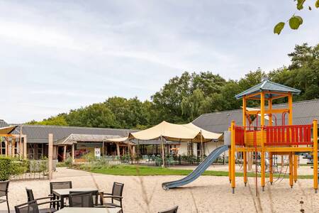 Speeltuin met terras bij het centrumgebouw op vakantiepark Roompot Bospark Lunsbergen