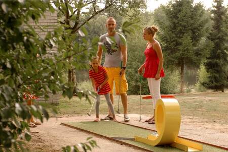 Gezin aan het golfen op de minigolfbaan op vakantiepark Roompot Bospark 't Wolfsven