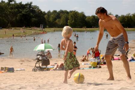 Mensen op het strand van het meer op vakantiepark Roompot Bospark 't Wolfsven