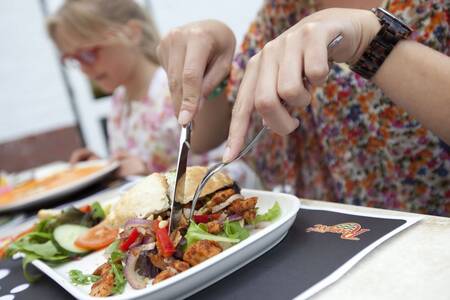 Een gezin dineert in een restaurant op vakantiepark Roompot Buitenhof Domburg