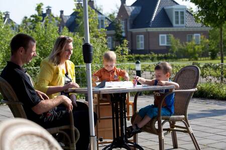 Gezin op het terras van het restaurant op vakantiepark Roompot Buitenplaats De Hildenberg