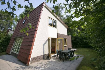 Tuin met tuinmeubels op het terras van een vakantiehuis op Roompot Bungalowpark Hoenderloo